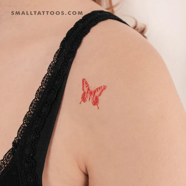 Red tattoos: A medium red butterfly tattoo on the shoulder