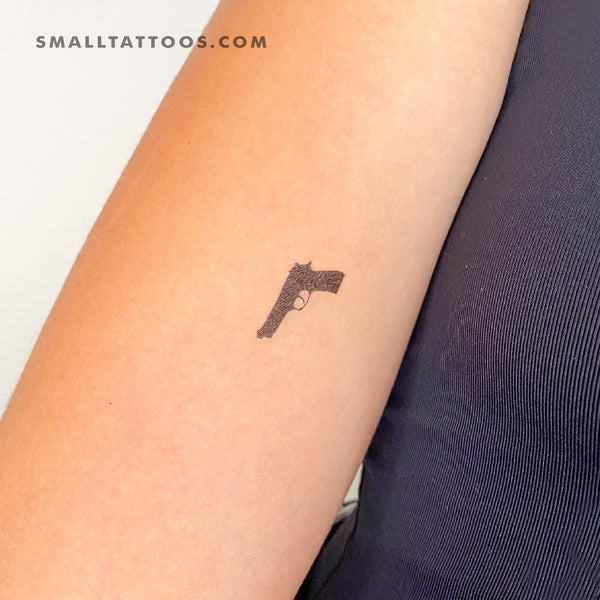 Gun tattoo on the left inner arm.