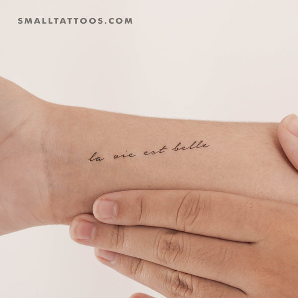 La vie en (p)rose lettering tattoo on the forearm.