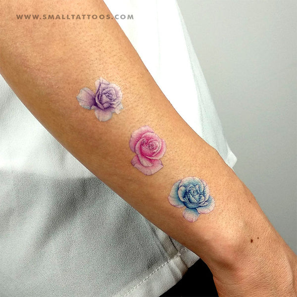 Watercolor red rose tattoo on the bicep.